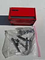 Red Snap-on metal toolbox with visible wear and chipping on corners and edges, closed