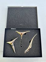 Set of three wine bottle accessories in foam insert: corkscrew, stopper, foil cutter.