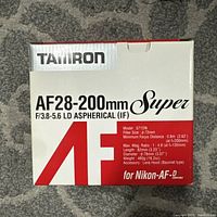 Top view of Tamron lens box showing model, focal length, aperture, filter size, minimum focus distance and max magnification ratio