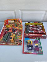 Overview of the lot showing all three items on table: Build King robot, Fire Engine Bot set, and Dinosaur Monsters set.