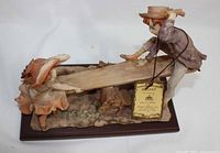 Side view of the Capodimonte Pucci porcelain sculpture showing children on a seesaw and base details