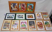 Top view showing all Disney framed art pieces arranged in two rows. Includes the three-in-one wooden frame at the top with Peter Pan, Lady & the Tramp, and Lion King pictures, with 11 individual framed prints below including multiple Snow White posters and smaller framed animal prints from Lion King and 101 Dalmatians.