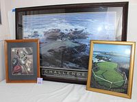 Three framed golf themed pictures arranged on a white cloth background: a large 'Challenge' golf poster, a medium gold framed golf course photo, and a small wooden framed golf clubs and balls artwork.
