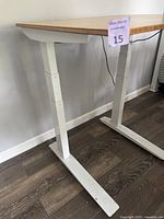 Close-up photo of the white metal legs and base of the desk, showing the sturdy frame construction and floor contact points.