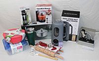 Wide view of kitchenware items including chopper, nut milk maker, soap dispenser, insulated tumbler, cookware, rolling pin, cookie cutters, and storage containers.