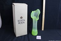 Green Kosta Boda box standing next to the green glass vase, size comparison with a ruler showing approximately 14 inches tall.