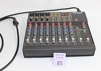 Mackie Micro Series 1202 mixer front left view showing control knobs, channel inputs, and power cord.