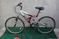 Full side view of the Next PowerX mountain bike, showing red and silver frame, tires, and black seat.