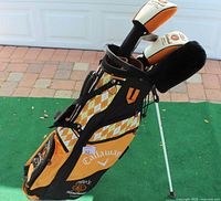 Full view of the Callaway golf bag with Tito's branding on green mat background