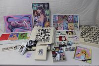 Full view of the entire VIP package contents including prints, tote bag, pin, stickers, postcards, and picture book.
