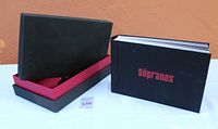 Black hardcover book-style box labeled 'Sopranos' in red font alongside the slipcover box with black exterior and red interior lining.