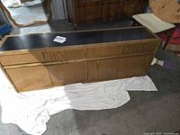 Front view of oak-tone cabinet with black laminate top