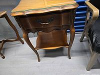 Front view of wooden side table showing drawer, legs, lower shelf