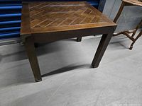 Front view of square wood accent table showing legs and parquet top