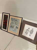 Four framed art prints placed on a sofa, showing variety in sizes and subjects