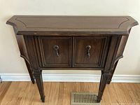 Front view of retro wooden hall table showing two drawers with metal keyhole handles and curved top edges.