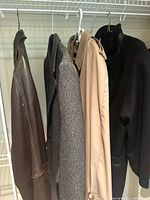 Photo of four hung coats on hangers showing variety and condition