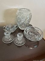 Photo of all items including a tall vase, small bowl with legs, two candle holders, sugar bowl