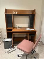 Desk with shelving, office chair, shredder and power bar visible.