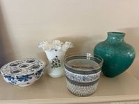 Photo showing 4 items together: white glass vase with floral painting, teal pottery vase, blue and white flower frog pot, and Egyptian style glass vase or ice bucket