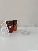 Full lot: two Godiva mugs, glass cake stand, honey jar with dipper
