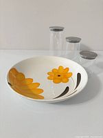 Top view of ceramic bowl with floral design and three glass canisters