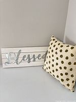 Wall sign leaning next to pillow showing overall look and scale