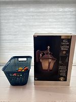 Boxed outdoor wall lantern next to basket of ceramic knobs