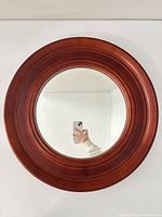 Front view of round mahogany wood framed mirror