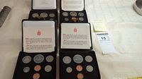 Four sets of Canadian uncirculated coins displayed in original presentation cases, showing various denominations and packaging.