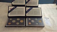 Four Royal Canadian Mint specimen coin sets from 1992 to 1995 displayed open to show coins and accompanying informational inserts.