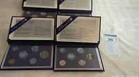 Four blue cases containing Royal Canadian Mint specimen coin sets, displayed with six coins each in protective holders.