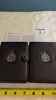 Two black leatherette cases with Canadian coat of arms, containing the coin specimen sets.