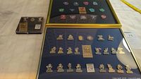 Two framed collections of collectible pins from the 1993 and 1994 Canada Games displayed on a surface with measuring tape visible (frames approximate 13x10 inches).