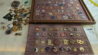 Two framed collections of pins and loose assorted collectible pins laid out on a surface