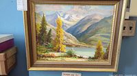 Full view of framed oil painting showing Mirror Lake BC landscape with lake, trees, mountains, and sky.
