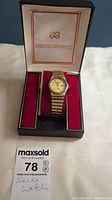 Gold-tone Seiko Quartz wristwatch inside original SEIKO QUARTZ box with red velvety interior.