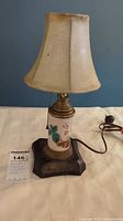 Full view of vintage boudoir lamp with beige fabric shade, showing pull-chain and electric cord.