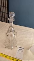 Full view of the clear glass vintage decanter showing overall shape, body design, and stopper.