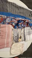 Photo of various spa cover ups, pestemals, and scrub mitts laid out showing colors and patterns
