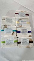 Seven bar soap set wrapped in textured paper with leaf prints and labels showing different soap scents.
