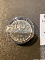 Reverse side of 1985 Canadian silver dollar coin with commemorative design and date 1985.