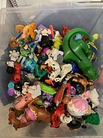Overhead photo showing all plastic character toys inside a clear plastic storage bin.