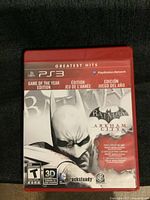 Front cover of the PS3 Batman: Arkham City Game of the Year Edition showing Greatest Hits red case and Batman artwork.