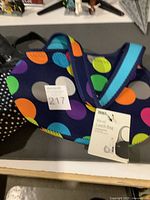 Photo of navy lunch bag with multicolored circles and tag visible