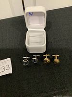 Pair of four cufflinks with white display box showing gold-tone ribbed cufflinks and silver-tone blue stone cufflinks