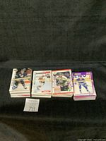 Four stacks of hockey trading cards with visible players and colorful borders, placed on black background with lot number 78 visible.