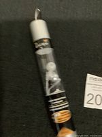 Pair of white and silver Escape HP-940 noise reduction earbuds in cylindrical retail packaging with black label and silver top/bottom, displayed on black surface.