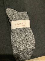 Three pairs of women's socks in black and grey marled pattern, each wrapped with Esprit band, shown folded on dark fabric background.