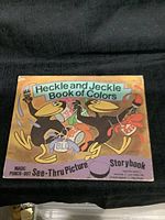 Cover of storybook showing Heckle and Jeckle holding paintbrushes and paint cans labeled red and blue, title on top